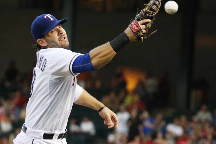 Texas first baseman Mitch Moreland leaps but can't get to a wild through to first by right...