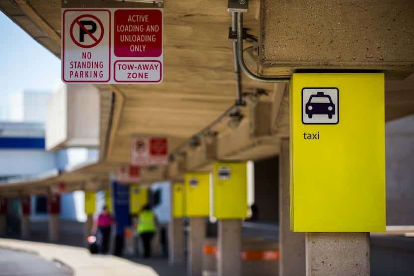 A sign designating the taxi cab waiting area is posted at Terminal A at DFW International...