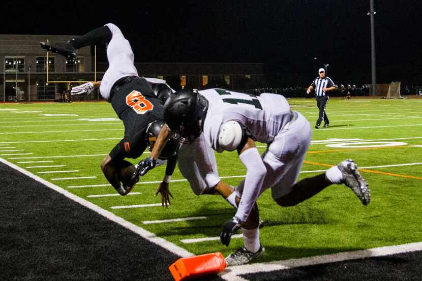 Lancaster quarterback Trevor Hatton (8) is flipped up in to the air by Mansfield Lake Ridge...
