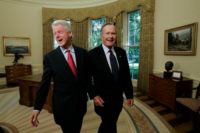 Former Presidents Bill Clinton and George H.W. Bush in the Oval Office after a joint...