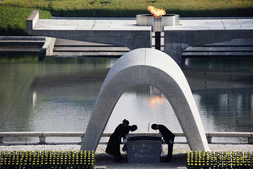Hiroshima mayor Kazumi Matsui, right, bows at Hiroshima Memorial Cenotaph during the...
