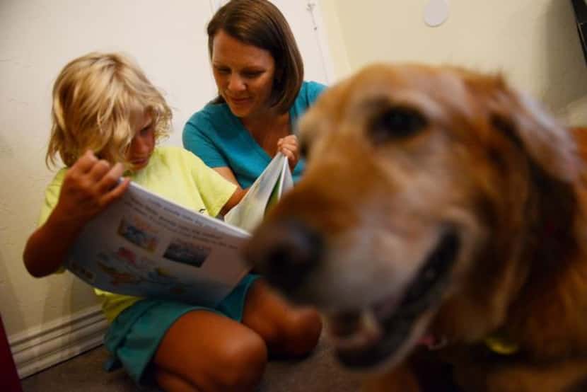 
Angel Jones reads to Joni Brock and her dog, Sandy, a golden retriever.
