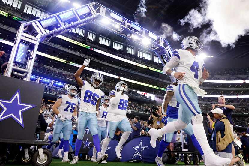 Dallas Cowboys quarterback Dak Prescott (4) and his teammates run onto the field to face the...