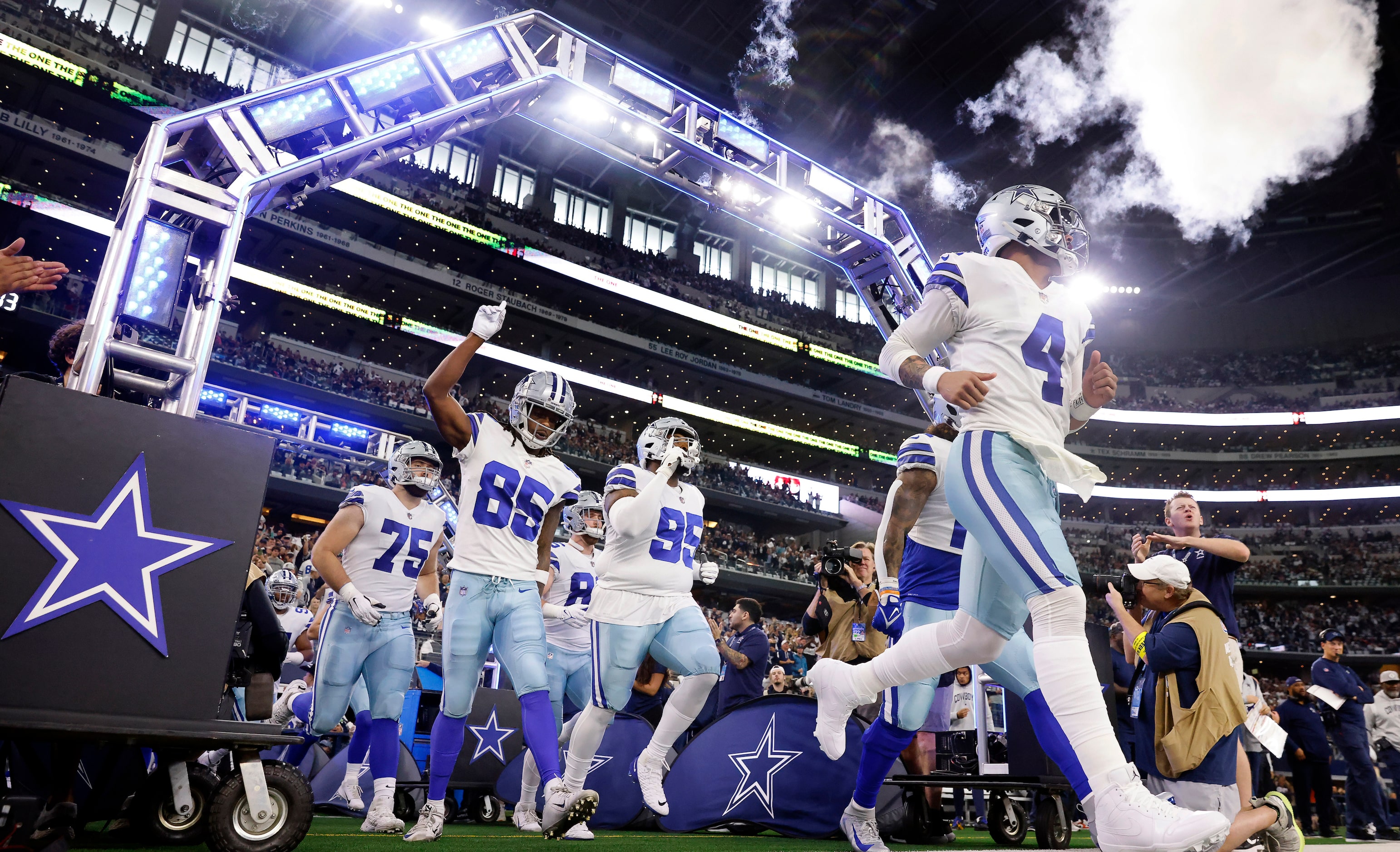 Dallas Cowboys quarterback Dak Prescott (4) and his teammates run onto the field to face the...