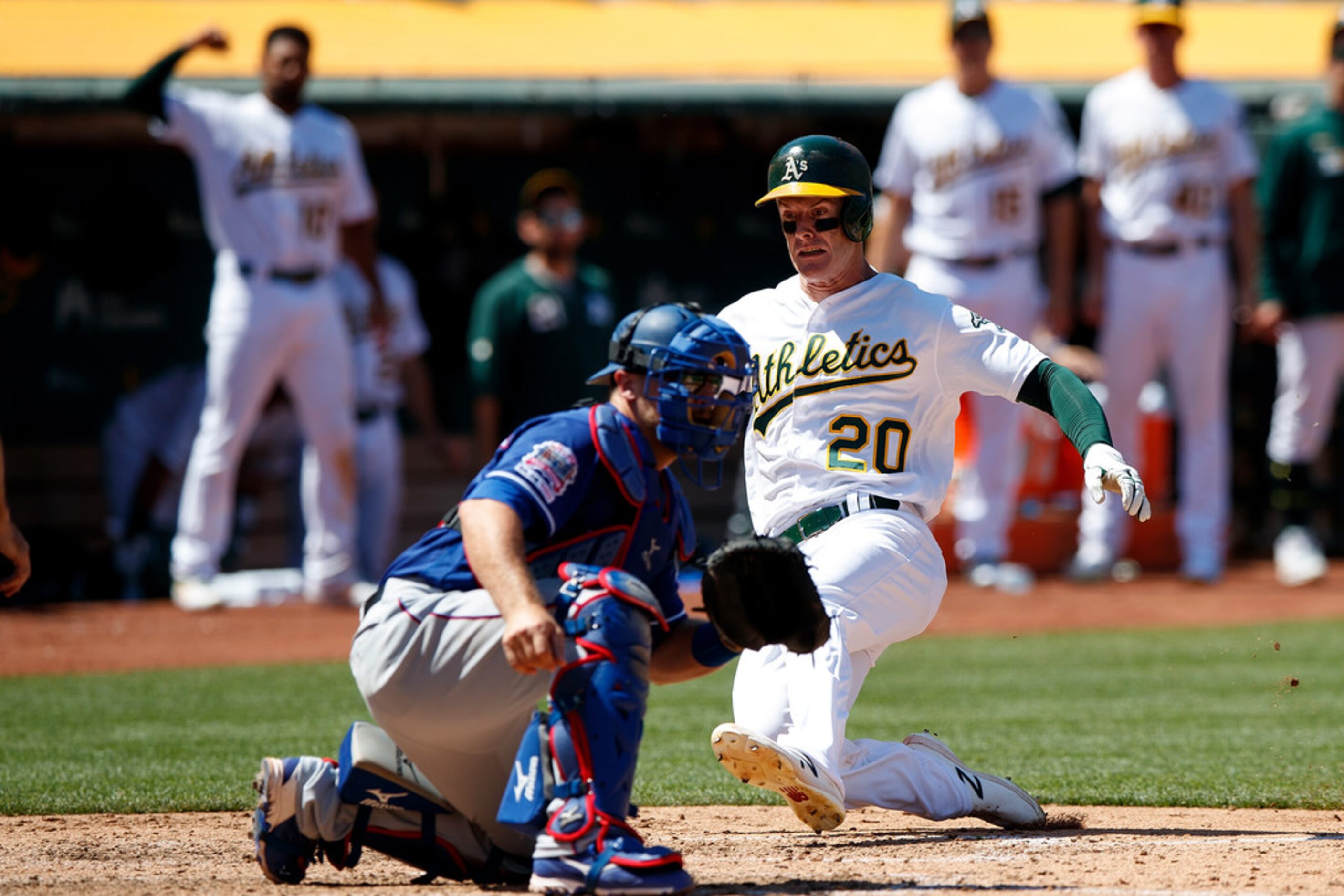 OAKLAND, CA - JULY 28:  Mark Canha #20 of the Oakland Athletics slides into home plate to...