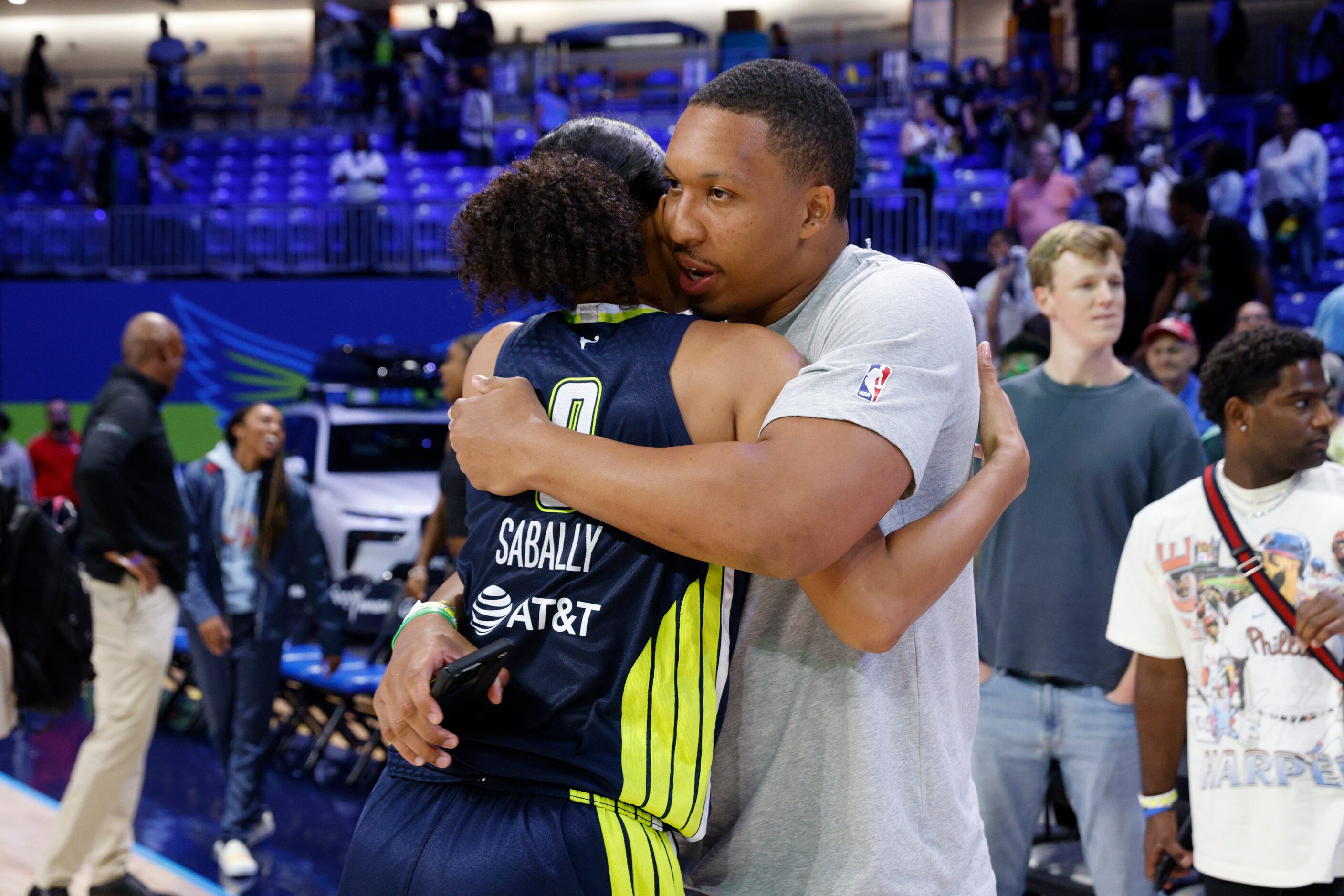 Dallas Wings forward Satou Sabally (0) hugs Dallas Mavericks player Grant Williams after a...