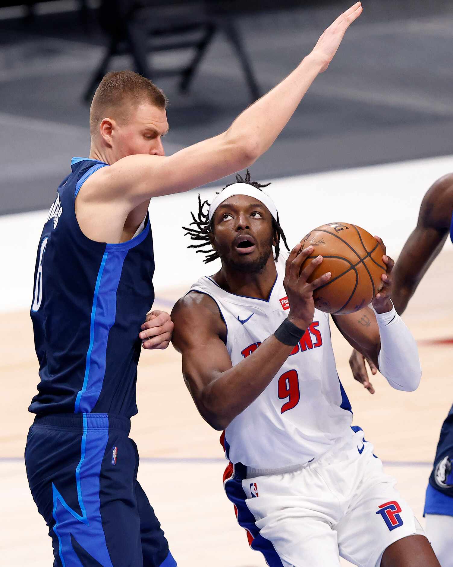 Detroit Pistons forward Jerami Grant (9) tries to go under Dallas Mavericks center Kristaps...