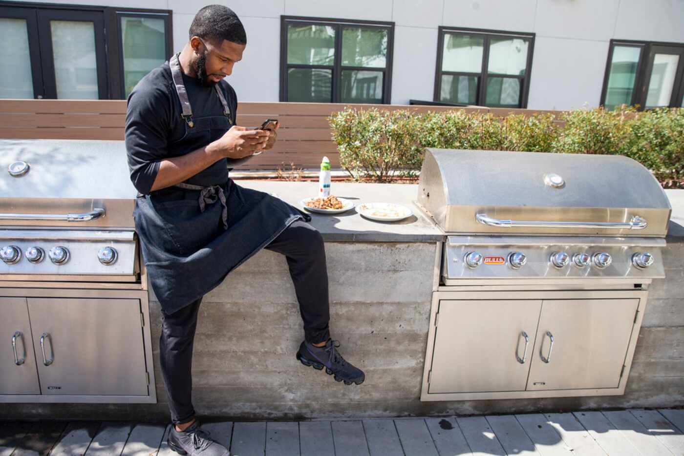 Chef Kev Ashade waits for his chicken and beef suya to cook at his Dallas home on Wednesday,...