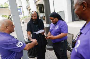 From left, Raj Paragh, street outreach worker with Downtown Dallas, Inc., shakes Spencer...