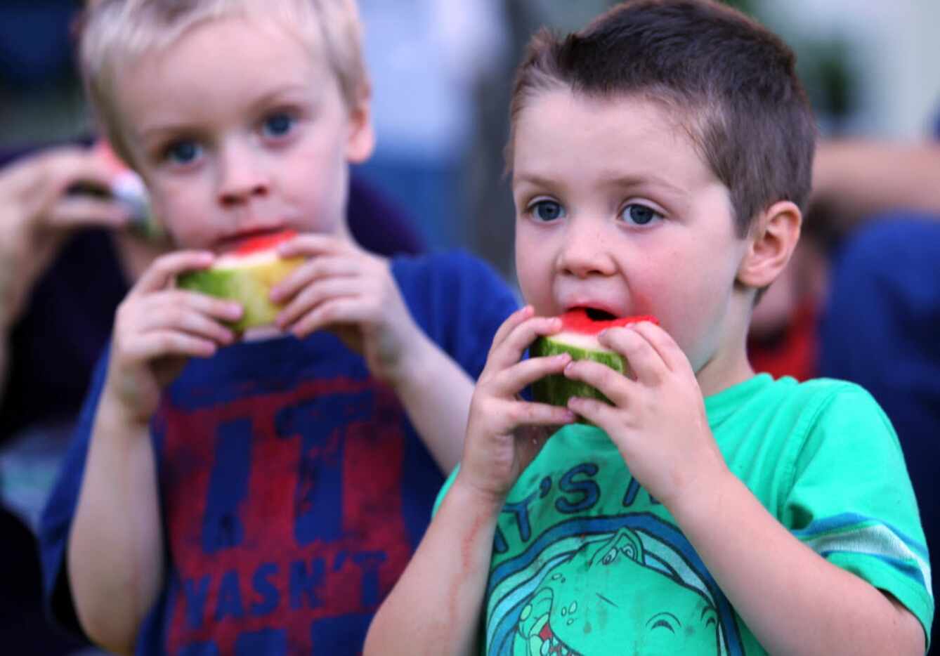 Cousins Aiden Anderson and Zade Brown snack on watermelon at a Dallas Symphony Orchestra...