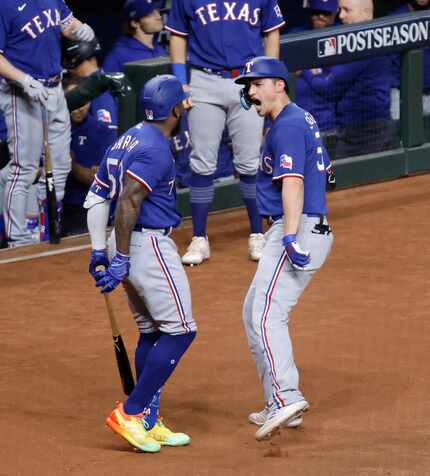 Texas Rangers Corey Seager (right) is congratulated on his solo home run by teammate Adolis...