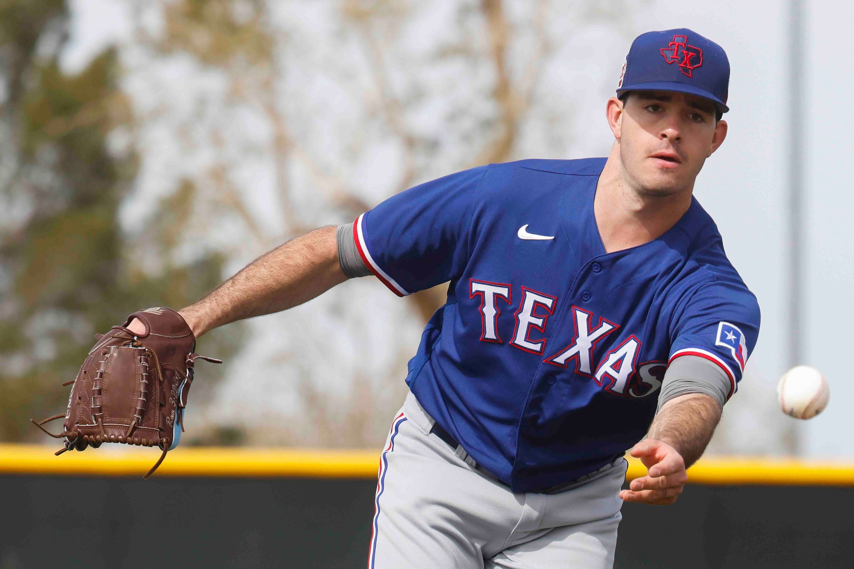 Texas Rangers pitcher Cody Bradford take part in a drill during a spring training workout at...