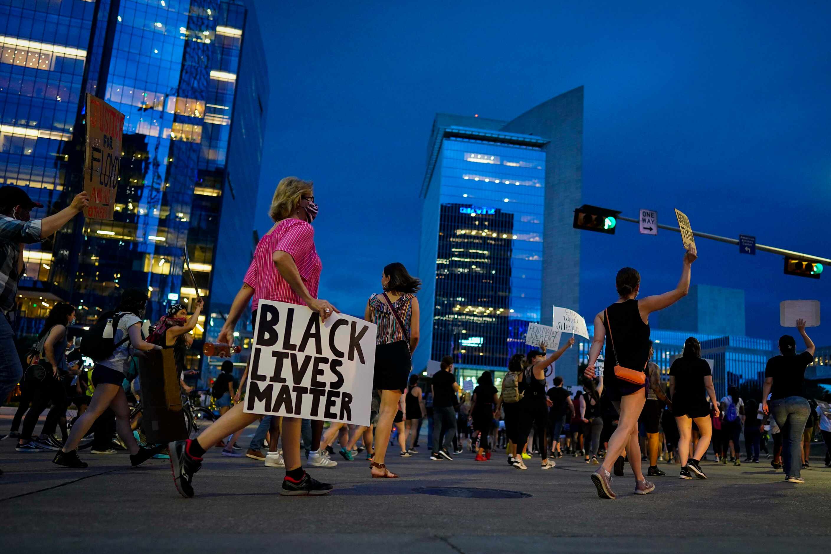 A group of marchers heads toward the Federal Reserve Bank of Dallas after rally for...