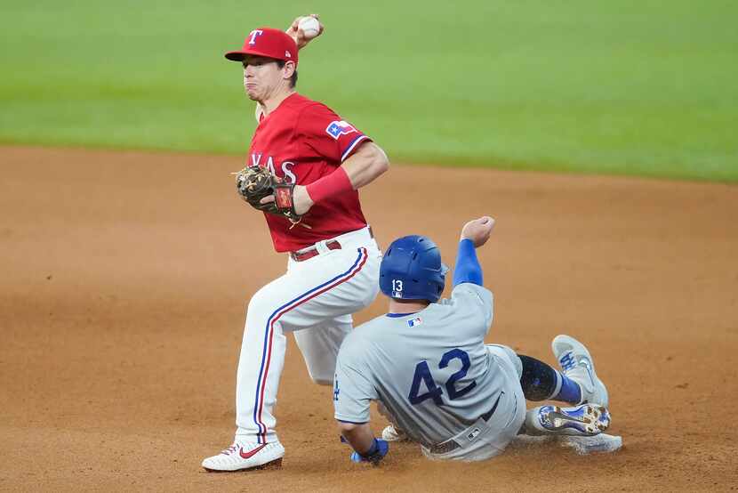 FILE - Rangers second baseman Nick Solak makes a relay over Dodgers third baseman Max Muncy...