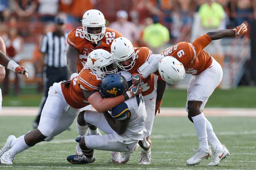 Texas Longhorns defensive end Charles Omenihu (90), safety Dylan Haines (14) and cornerback...