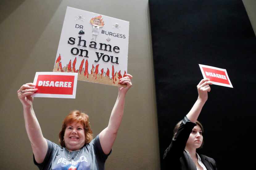 Sandra Cooley of Fort Worth, left, and Kate Banks of Denton, show their disagreement with...