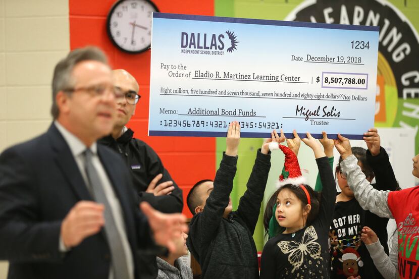 Students hold up a a check for additional bond funds to improve Eladio R. Martinez Learning...
