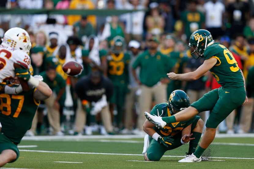 Baylor Bears place kicker John Mayers (95) kicks the field goal attempt held by Baylor Bears...