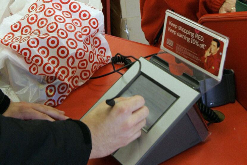 FILE - In this Jan. 18, 2008 file photo, a customer signs his credit card receipt at a...