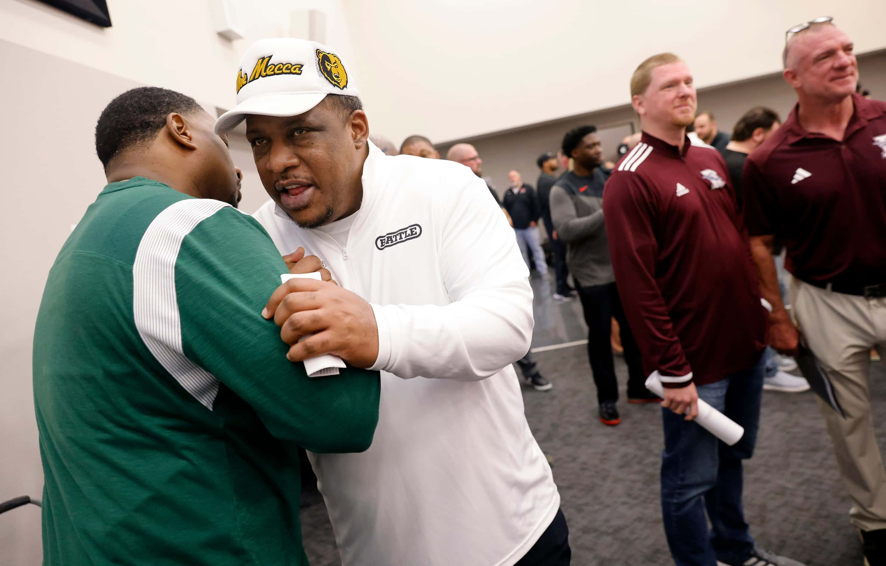 South Oak Cliff head football coach Jason Todd (right) is greeted by fellow coaches as he...