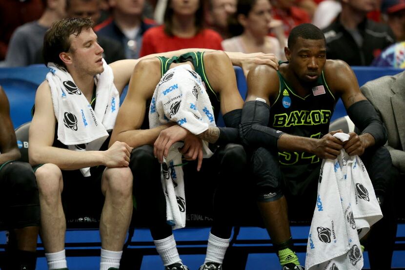 Brady Heslip #5, Isaiah Austin #21 and Cory Jefferson #34 of the Baylor Bears sit on the...