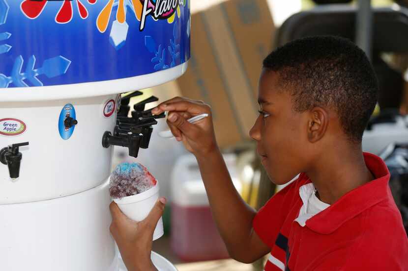 Ashton Smith, 12, makes a custom snow cone at the Snowie Southwest Shaved Ice Snow Cones...