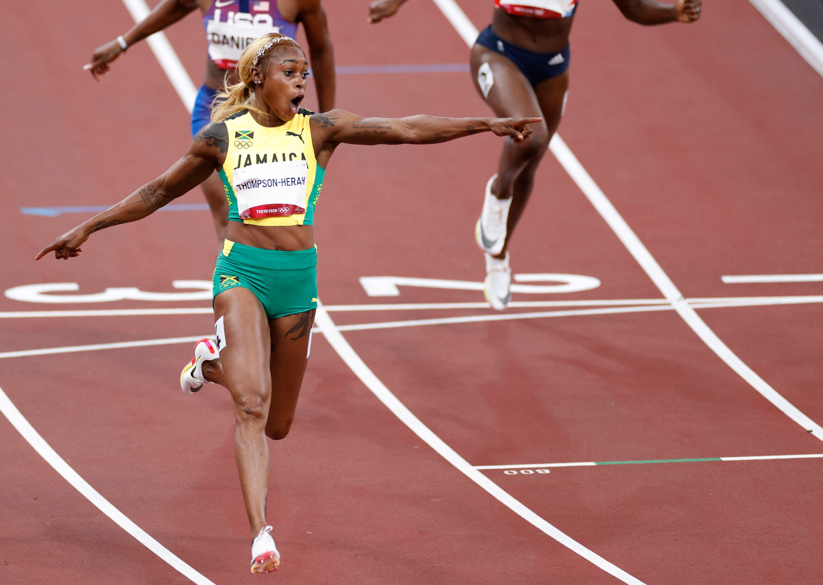 Jamaica’s Elaine Thompson-Herah celebrates as she comes across the finish line winning the...