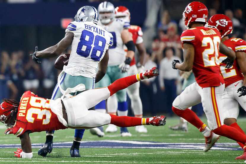 Dallas Cowboys wide receiver Dez Bryant (88) loses the ball as is hit by Kansas City Chiefs...