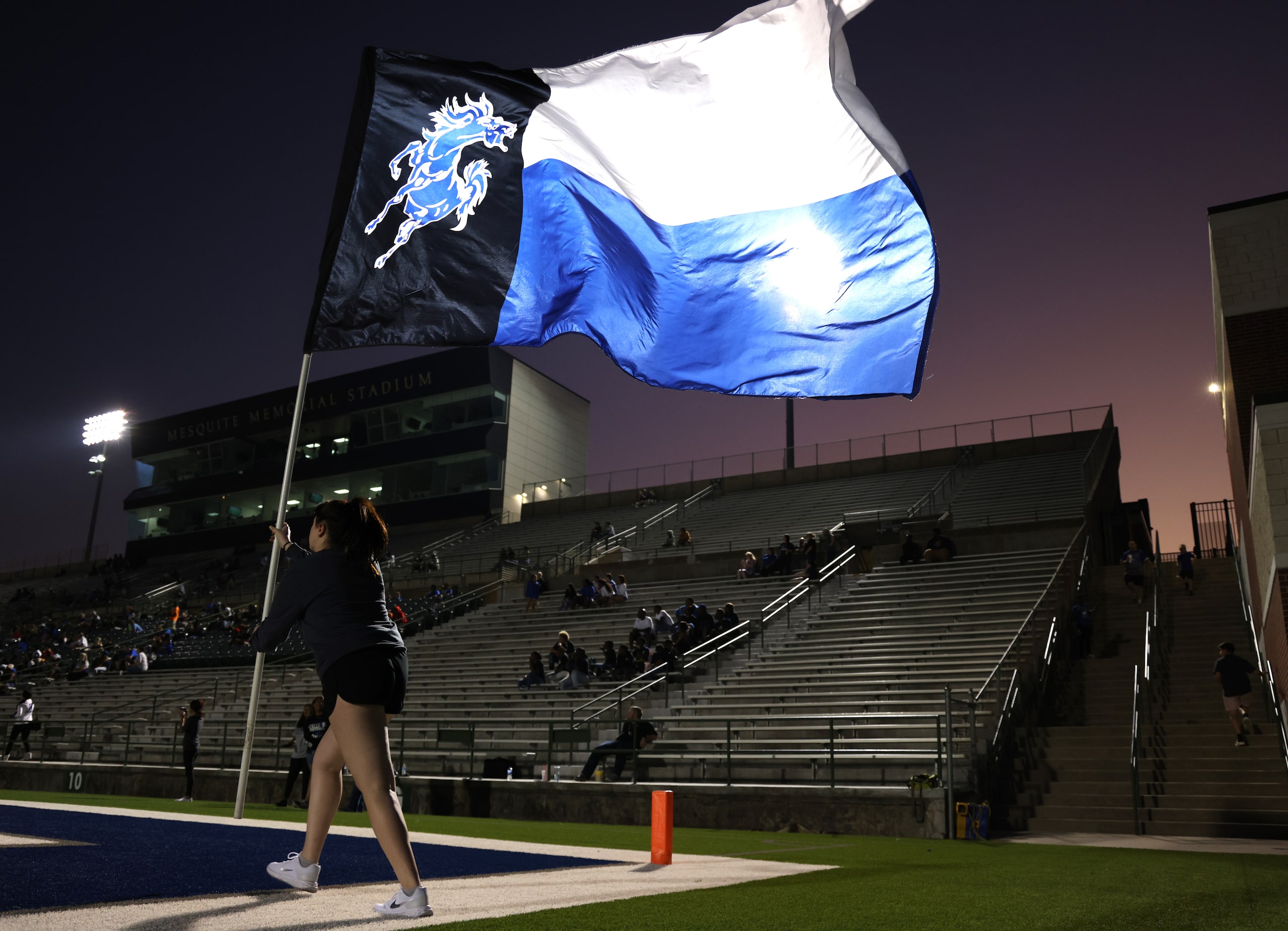 A member of the North Mesquite Stallions flag waving team prepares to cross the field...