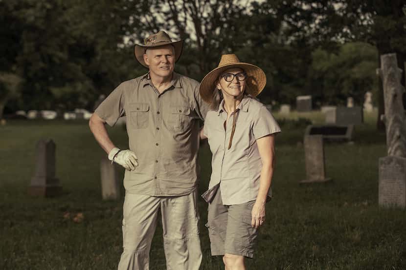 man and woman pose for picture in middle of a cemetery