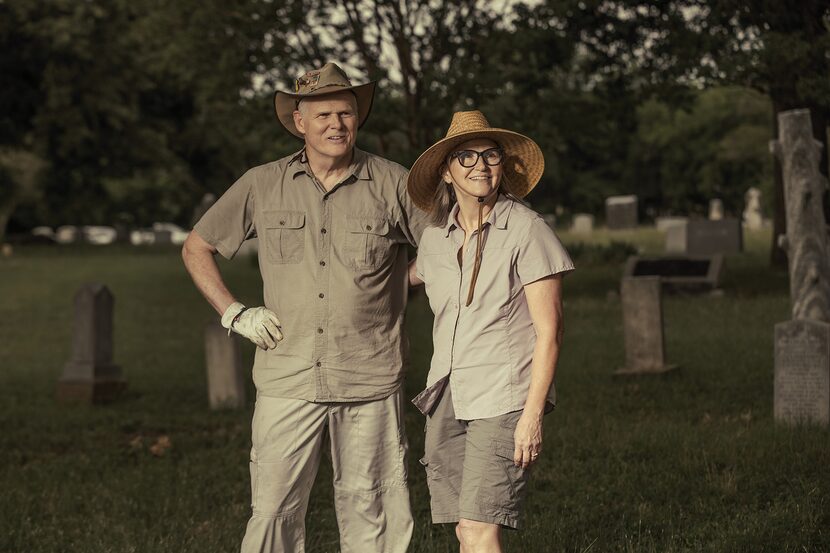 man and woman pose for picture in middle of a cemetery