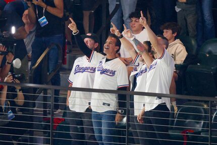 The band Creed reacts to being shown on the video board before the start of the third inning...