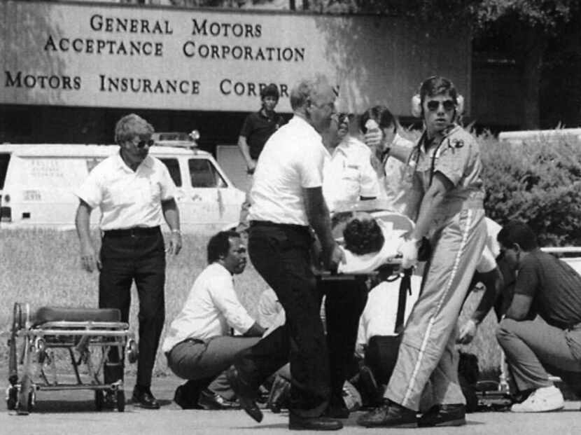 Rescue workers attend to one victim as another is moved to a waiting ambulance on June 18,...
