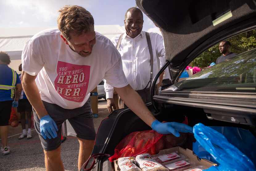 Dallas Mavericks Hall of Famer Dirk Nowitzki and state Sen. Royce West  loaded cars during...