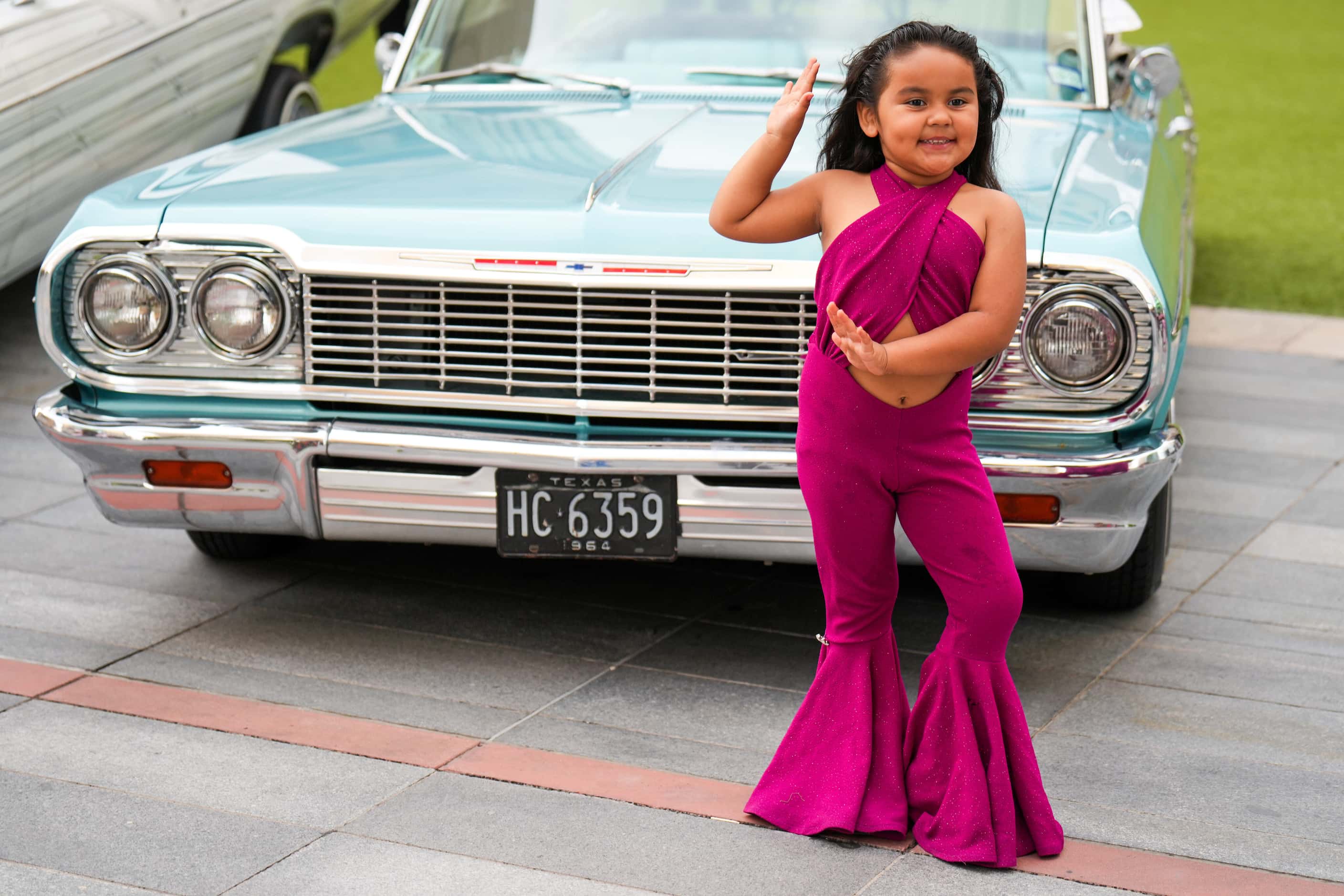Galilea Huerta, 5, strikes a pose next to a display of low riders during a celebration of...