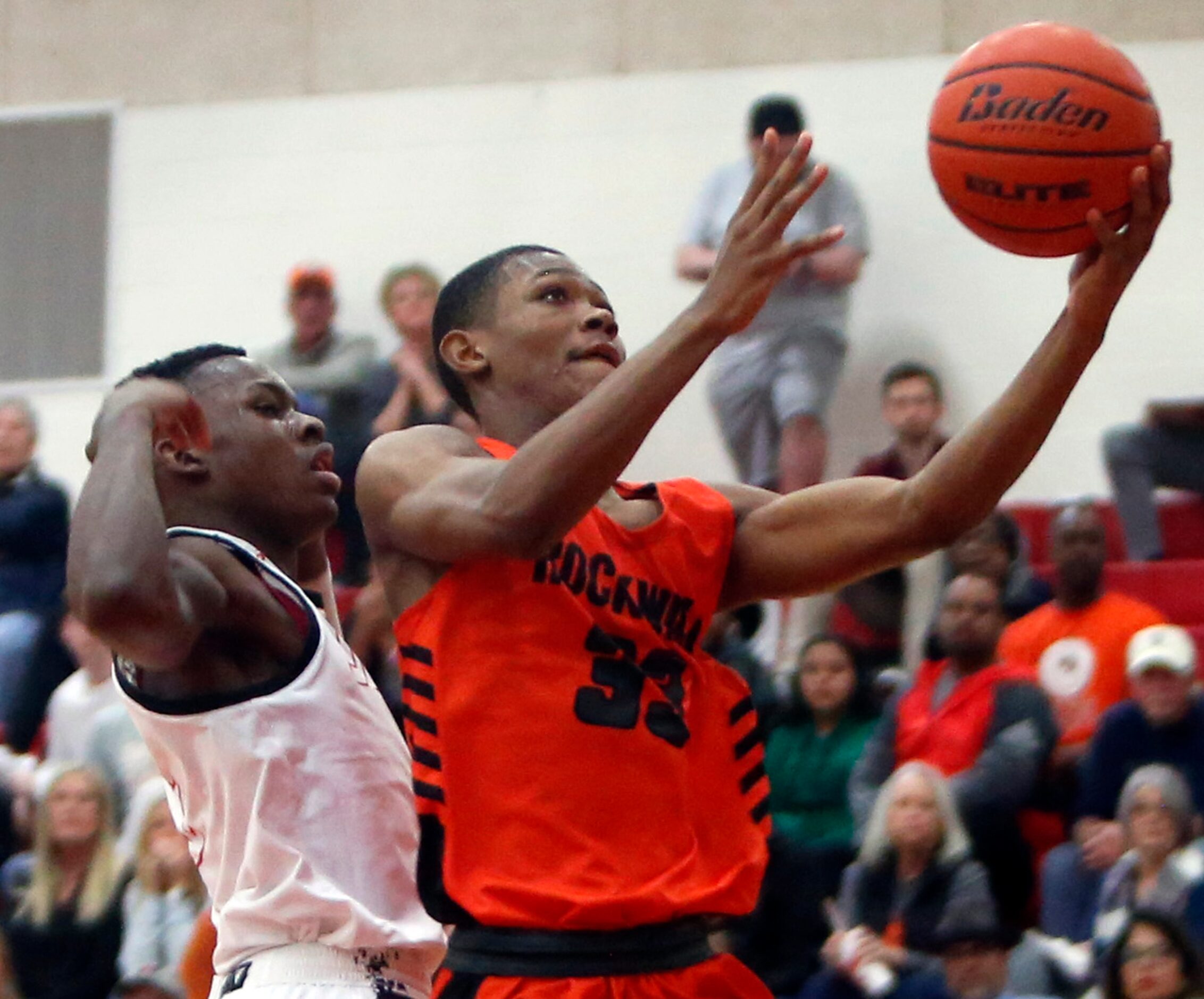 Rockwall's Sherman Brashear (33) scores on a drive to the basket as he is covered...