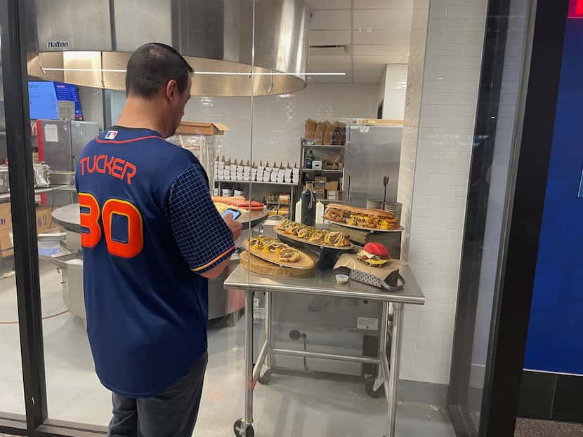 Un fan de los Astros de Houston observa la comida en una concesión del Globe Life Field, el...