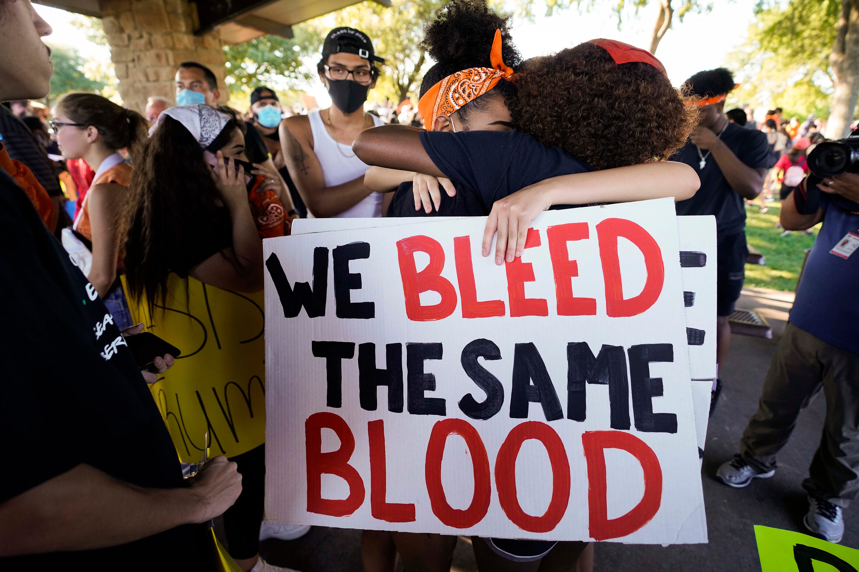 Monique Mitchell (facing) is buried in a group hug with classmates during a protest...