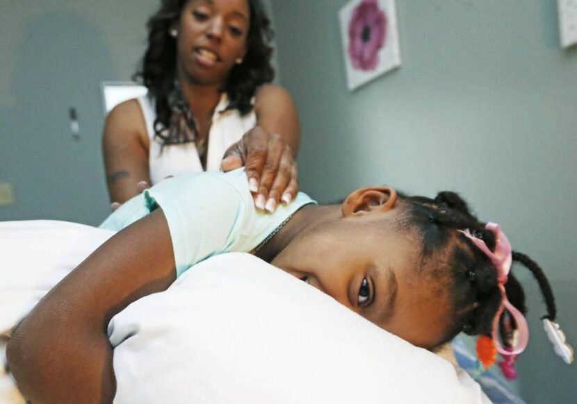  Massage therapist Ora Lee gives her autistic daughter Kennedy, 3, a massage. Photo by...