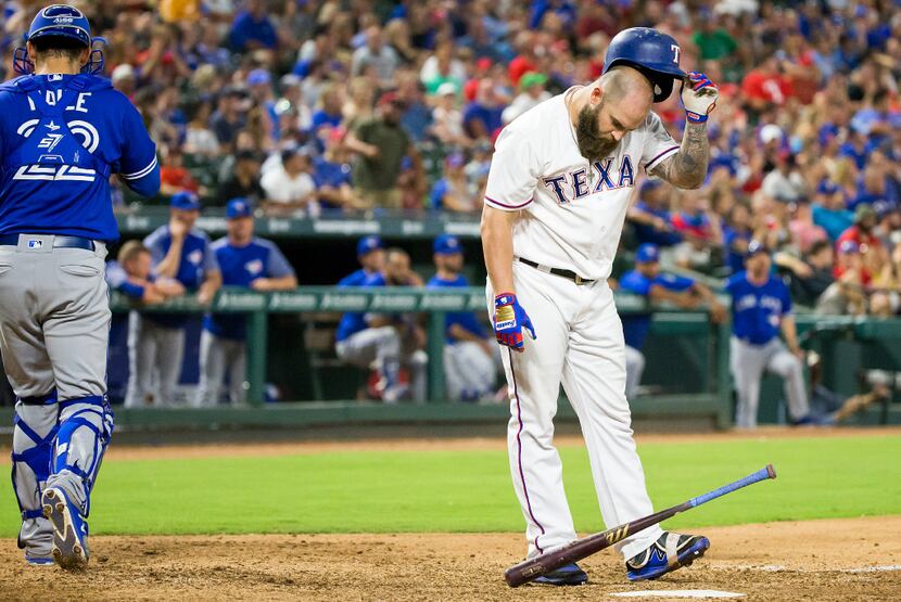 Texas Rangers first baseman Mike Napoli drops his bat and helmet after striking out to end...