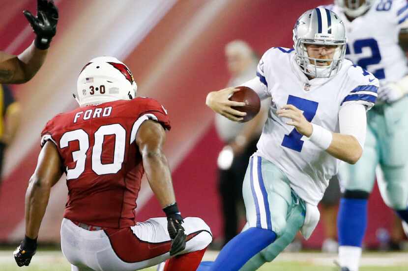 Dallas Cowboys quarterback Cooper Rush (7) attempts to break away from Arizona Cardinals...