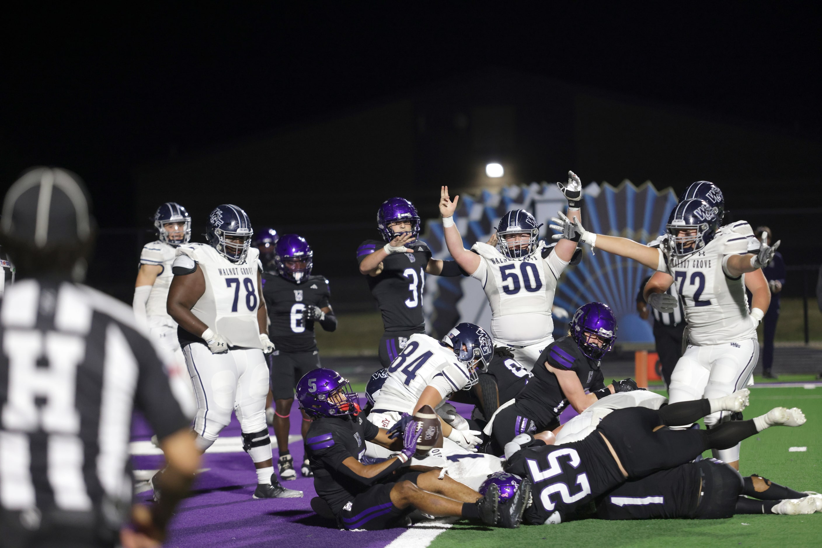 Walnut Grove players signal to a referee they believe a touchdown was completed during the...