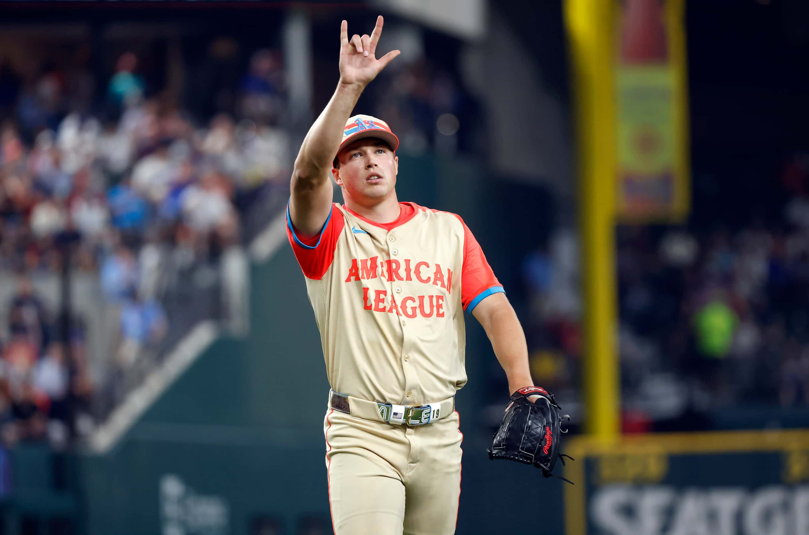 American League's Mason Miller, of the Oakland Athletics, flashes a hand sign to the crowd...