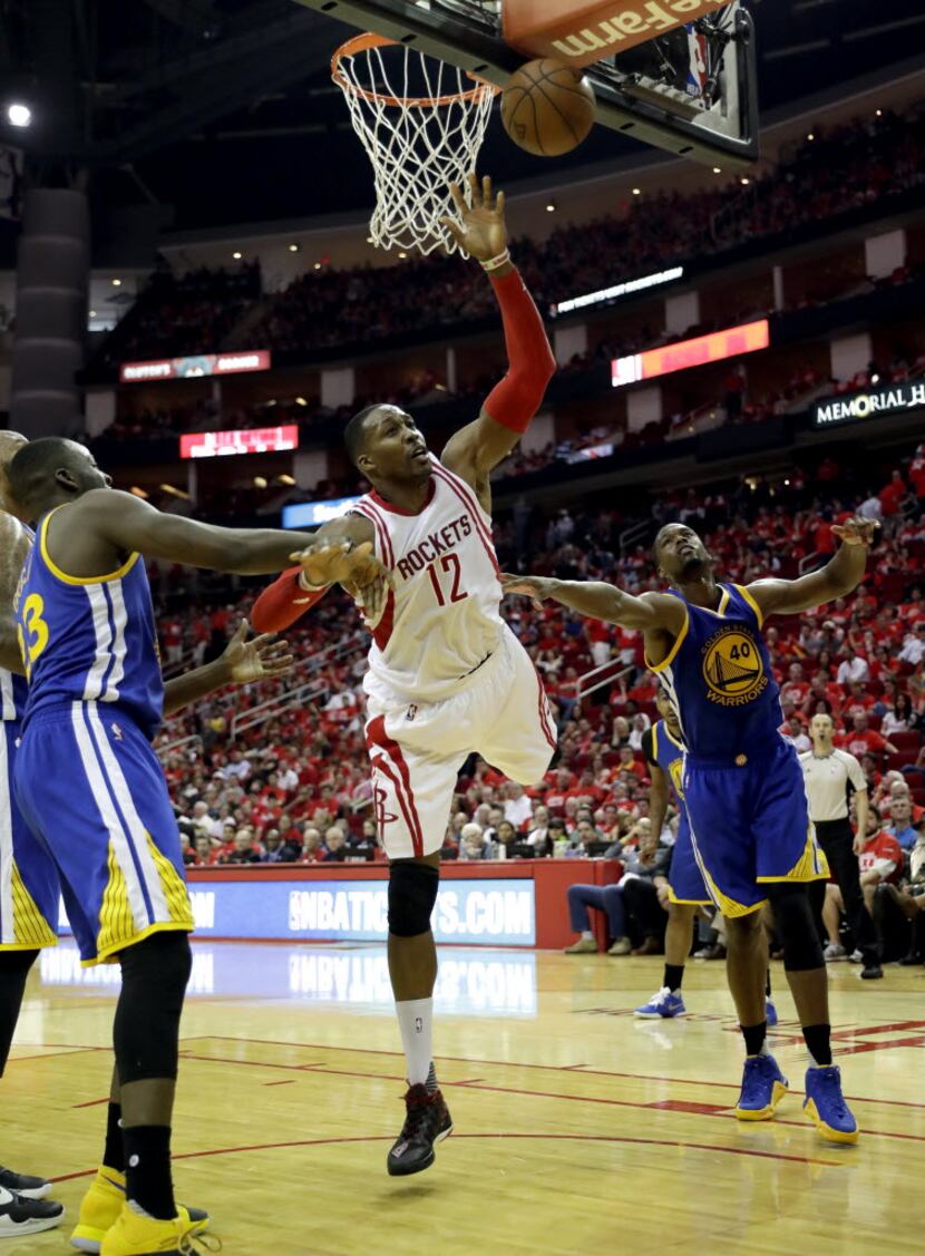 Houston Rockets' Dwight Howard, center, misses a basket as Golden State Warriors' Draymond...