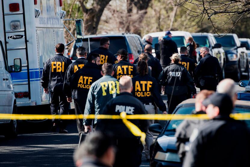 Authorities work at the scene of an explosion in Austin. A series of package bombs killed...