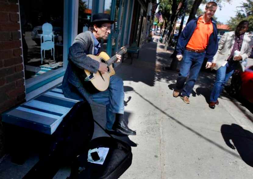 
Russ Higginbotham played his guitar on a bench for passers-by in Bishop Arts Friday...