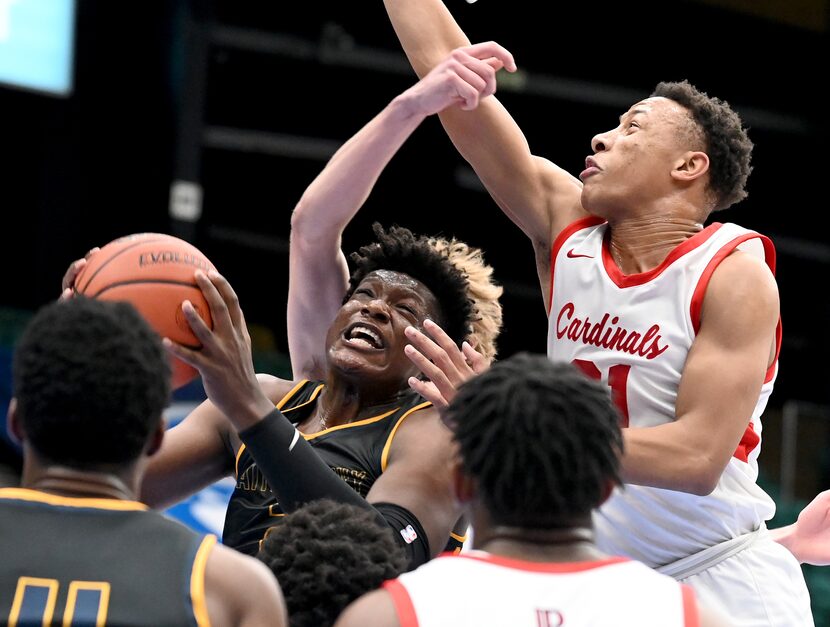 Faith Family’s Brandon Walker drives to the basket guarded by John Paul II’s Gabe Warren...