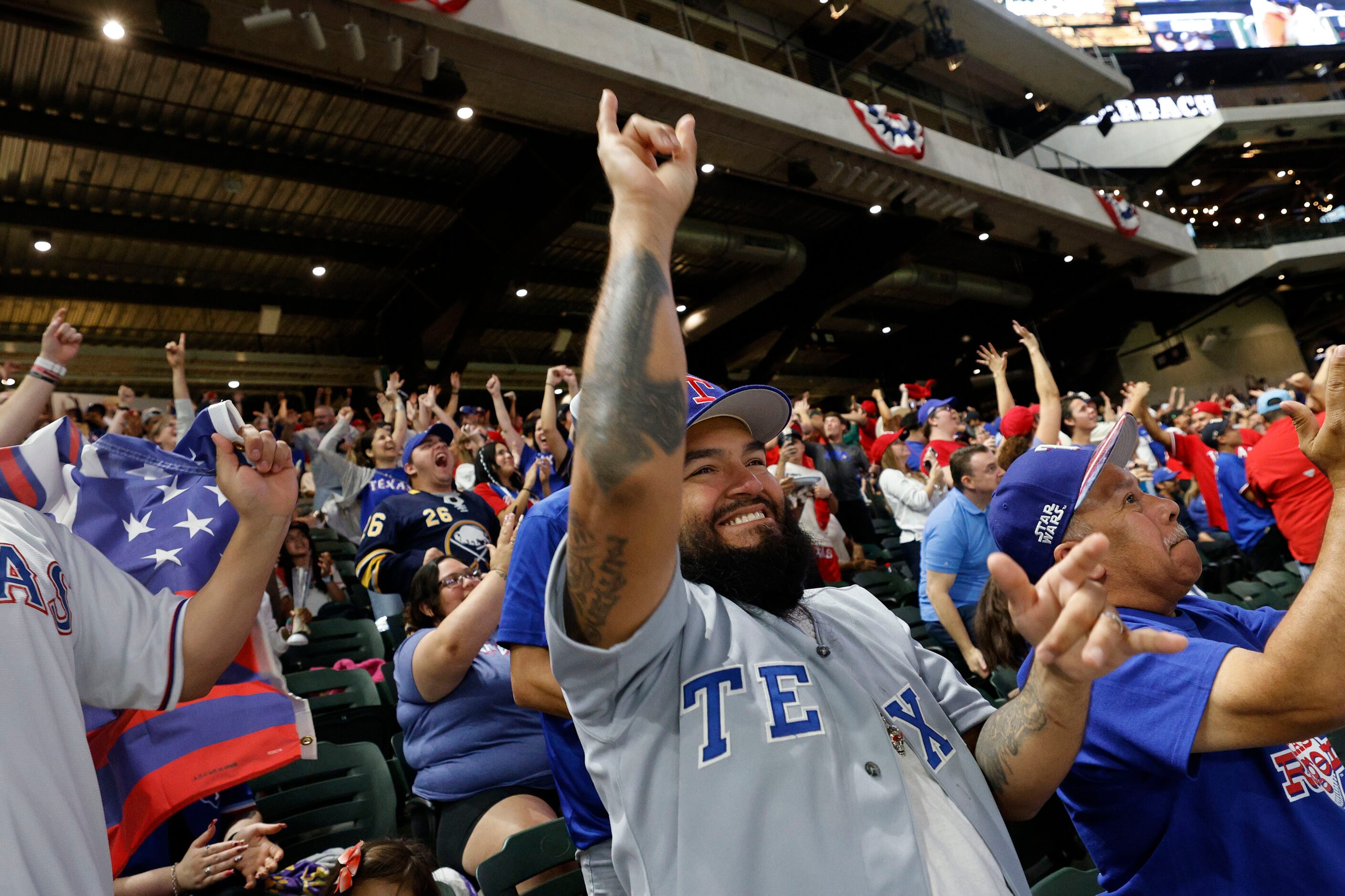 Texas Rangers fan John Sanchez of  Cedar Hill, center, reacts during a Game 7 watch party of...