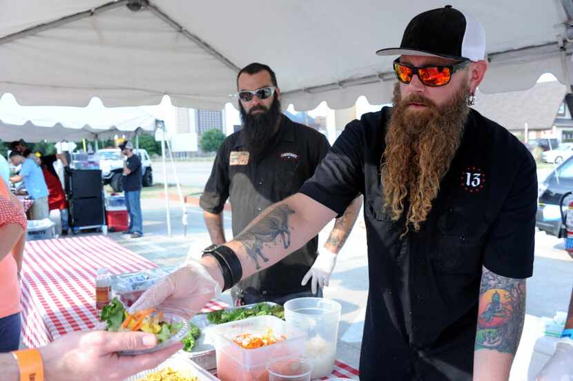 Pitmaster Will Fleischman, right, served a smoked dandelion green salad at a fundraiser in...