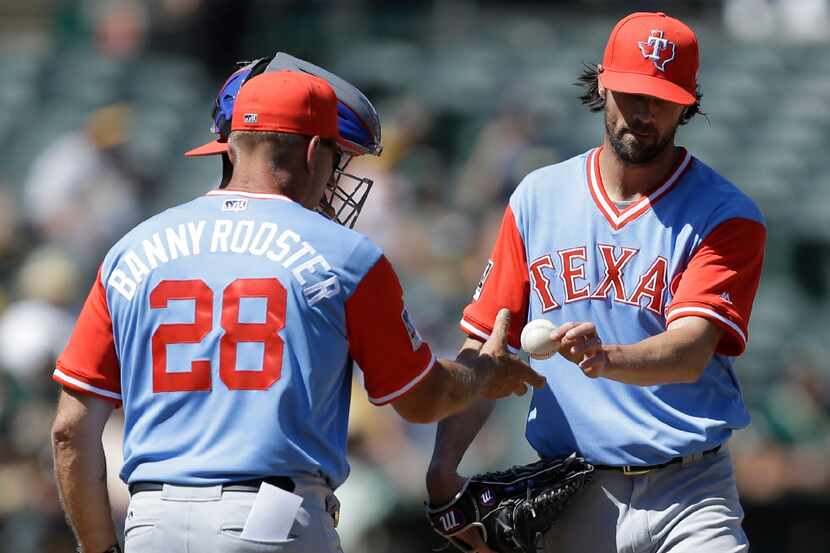 Texas Rangers pitcher Cole Hamels, right, hands the ball to manager Jeff Banister (28) after...